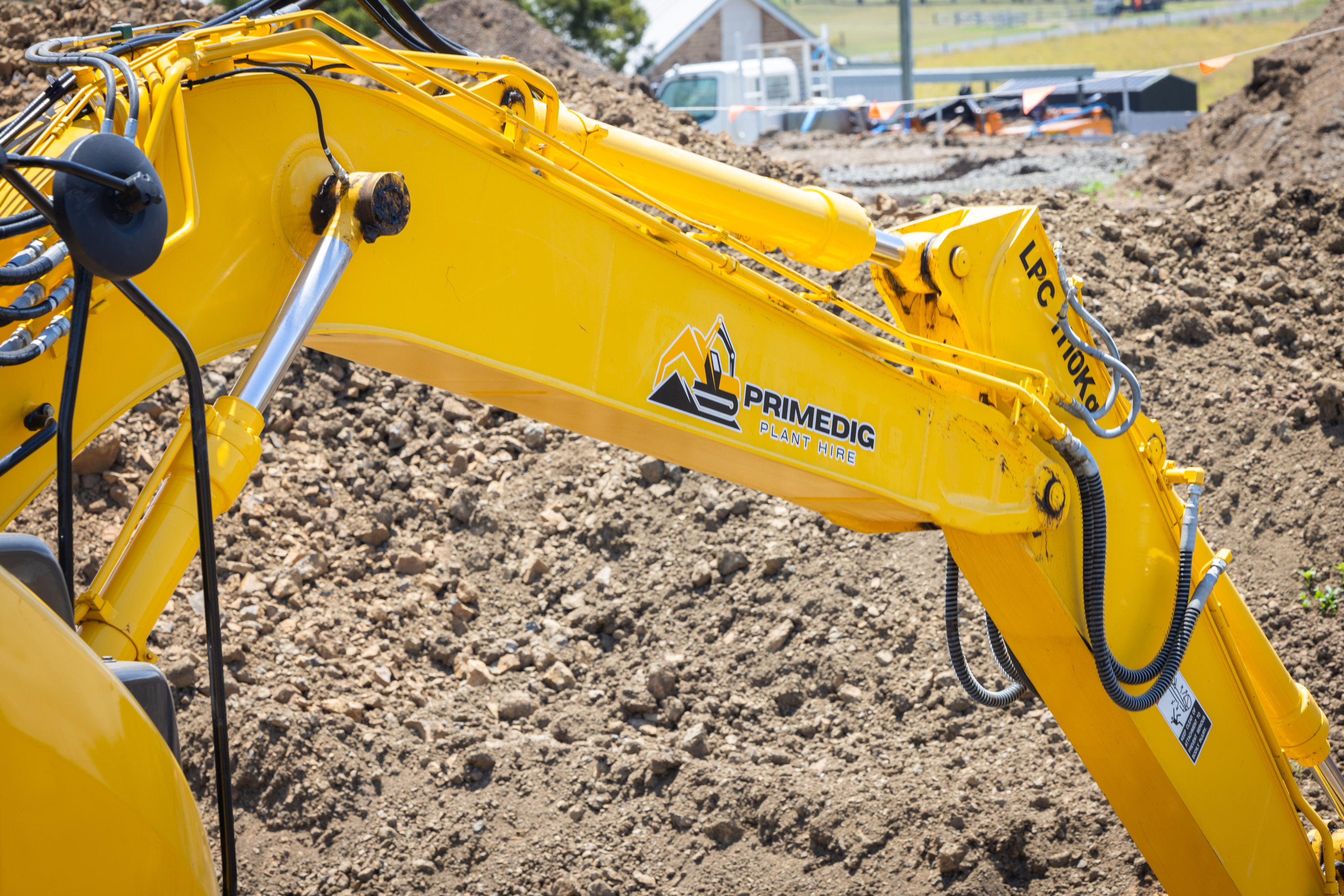 Excavator arm reaching over a dirt mound on a South East Queensland job site